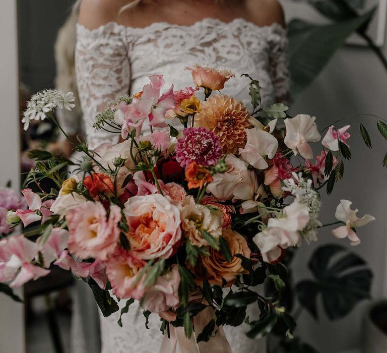 Colourful mixed floral bridal bouquet tied with light pink ribbon