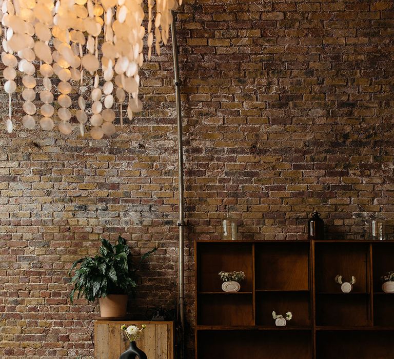 100 Barrington wedding venue reception room with large calathea plants in tan flower pots and wooden shelving units