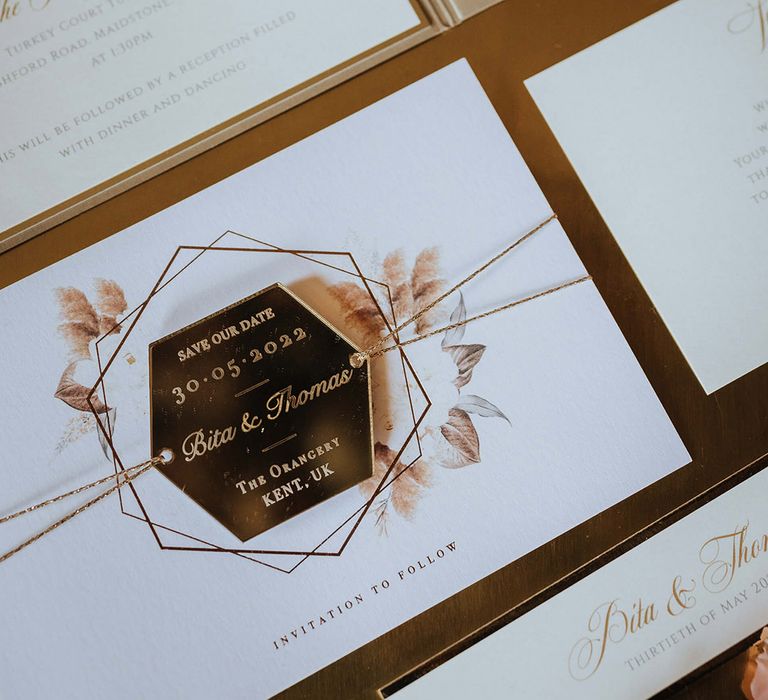 Classic and elegant white and gold wedding stationery include the save the date 