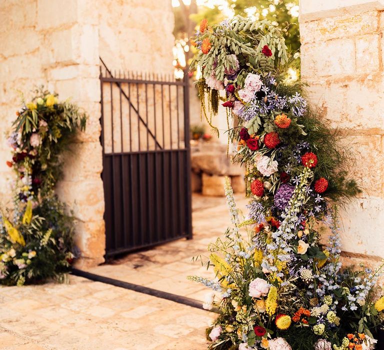 Destination wedding in Puglia with colourful red, yellow, purple, pink flowers for bright wedding 