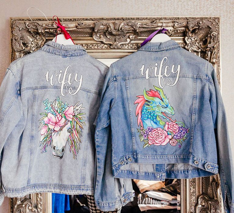 Two bridal personalised denim jackets with embroidered "wifey" lettering with a colourful unicorn and dragon embroidery 