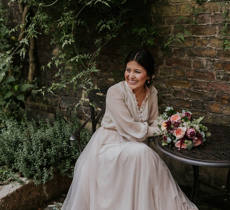 Bride wears chic buttoned blouse and tulle skirt bridal separates in neutral tones 