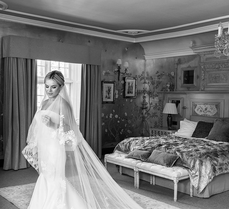 Bride in the bridal suite at The Manor House, Castle Combe for the classic wedding wearing a mermaid wedding dress and statement veil 