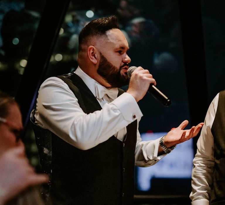 Groom in black waistcoat and white bowtie doing wedding speech at The Gherkin wedding venue 