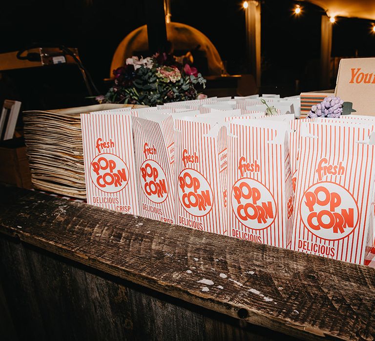 Red and white boxes of popcorn with fresh pizza for the evening food at the Wasing Park wedding 