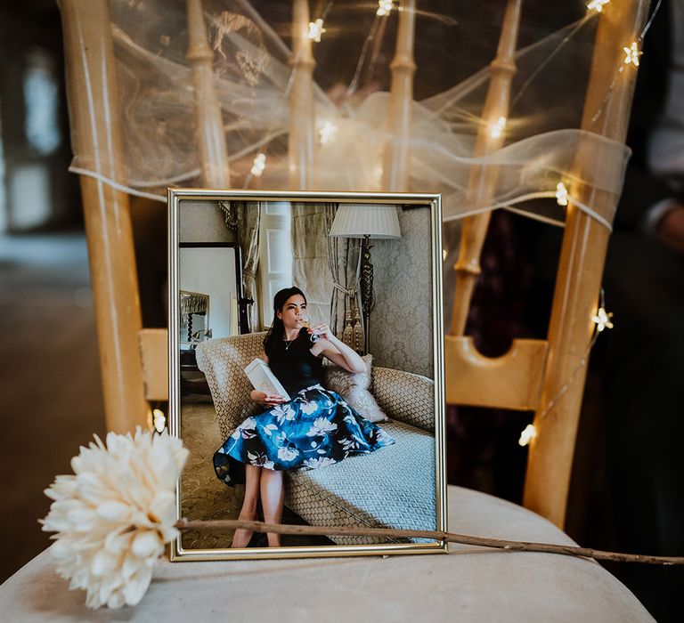 A large photo and flower in memory of the maid of honour on one of the seats at the ceremony 