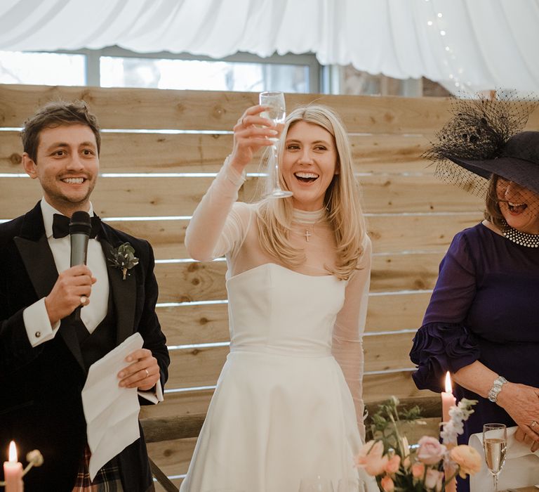 The bride and groom make a toast during the speeches on their wedding day 