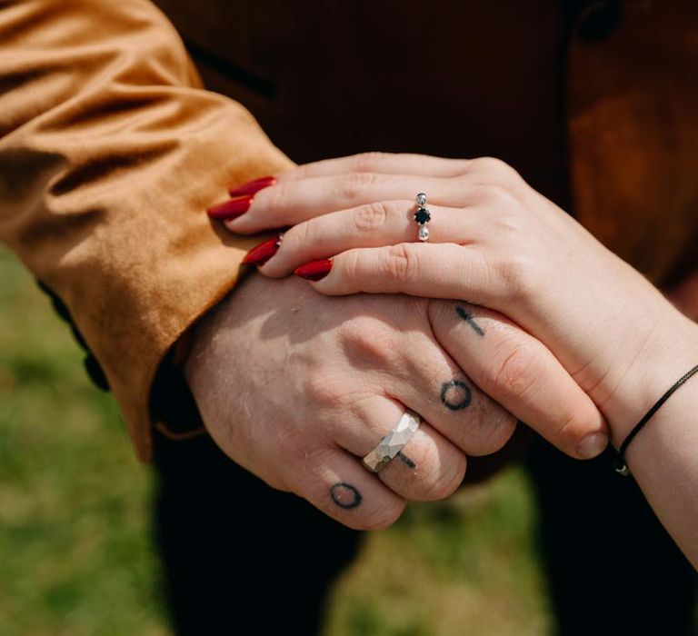 Bride and groom wearing alternative silver wedding rings 