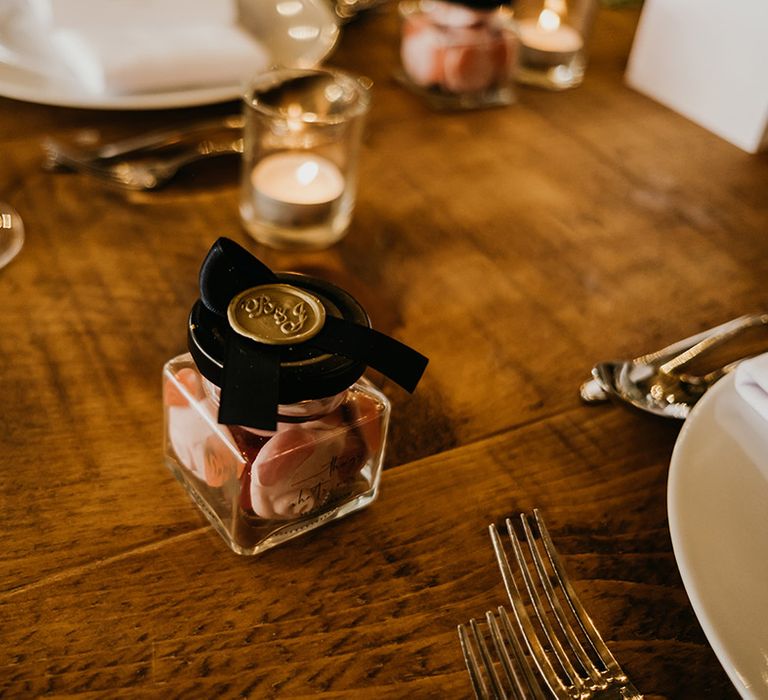 Stylish wedding favours for the wedding guests with gold wax seal pot of Percy Pig sweets