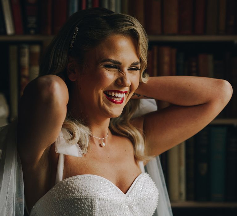 Bride wearing bold red lipstick in sparkly corset style Eva Lendel wedding dress 