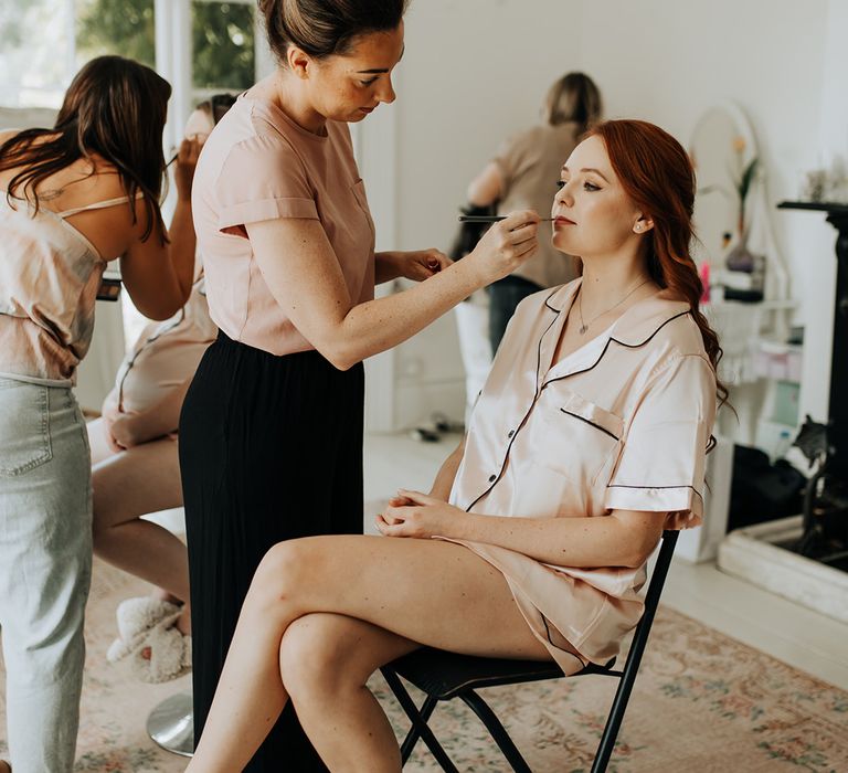 Bride in pink satin short set pyjamas getting ready for the wedding day 