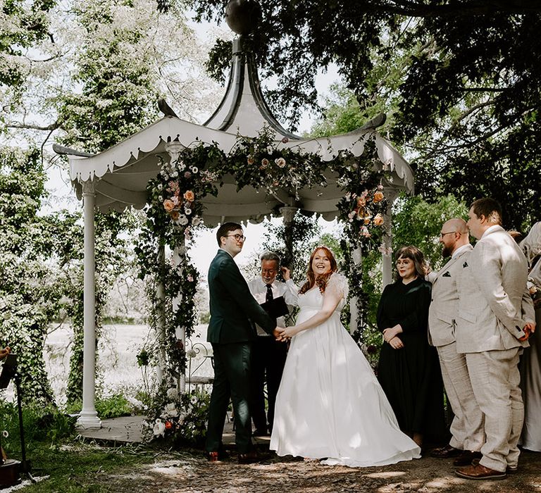 The bride and groom with their mixed gender wedding party standing next to them 