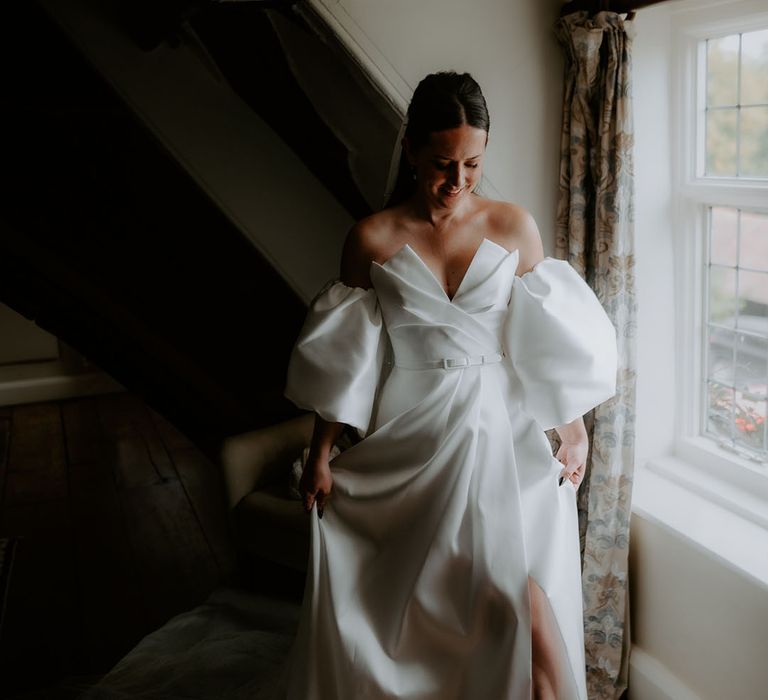 Bride wearing strapless wedding dress with stylish belt and pearl veil 