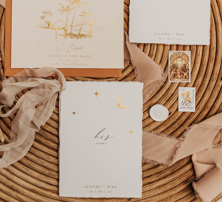 Wedding stationery flatlay with vow booklets and gold moon design 