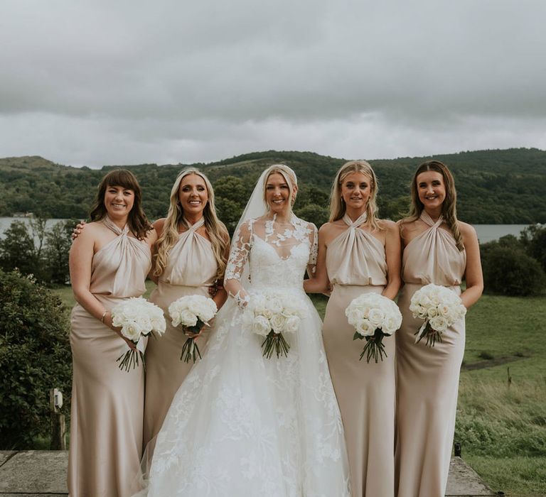 Bridal party wearing gold bridesmaid dresses for classic wedding with bride in lace gown 