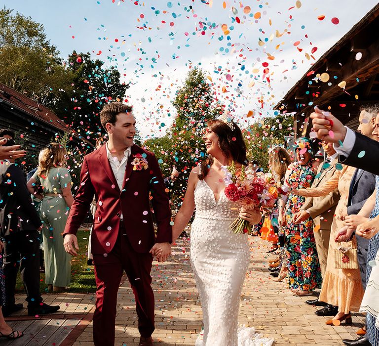 Bright and colourful wedding confetti exit for bride and groom 