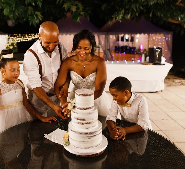 Bride and groom cut the wedding cake with family