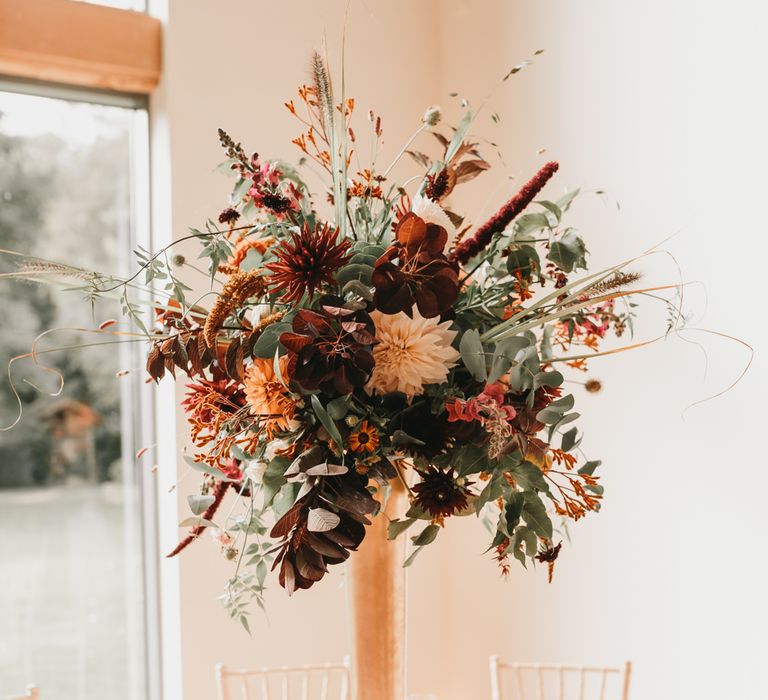 Tall autumn wedding flower centrepiece at Millbridge Court venue in Surrey