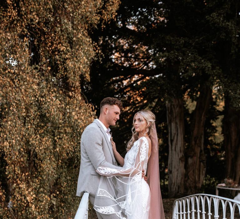 Couple standing over the lake bridge at Preston Court