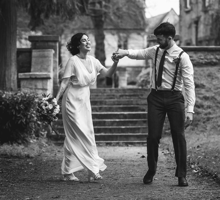 Bride and groom laughing in churchyard