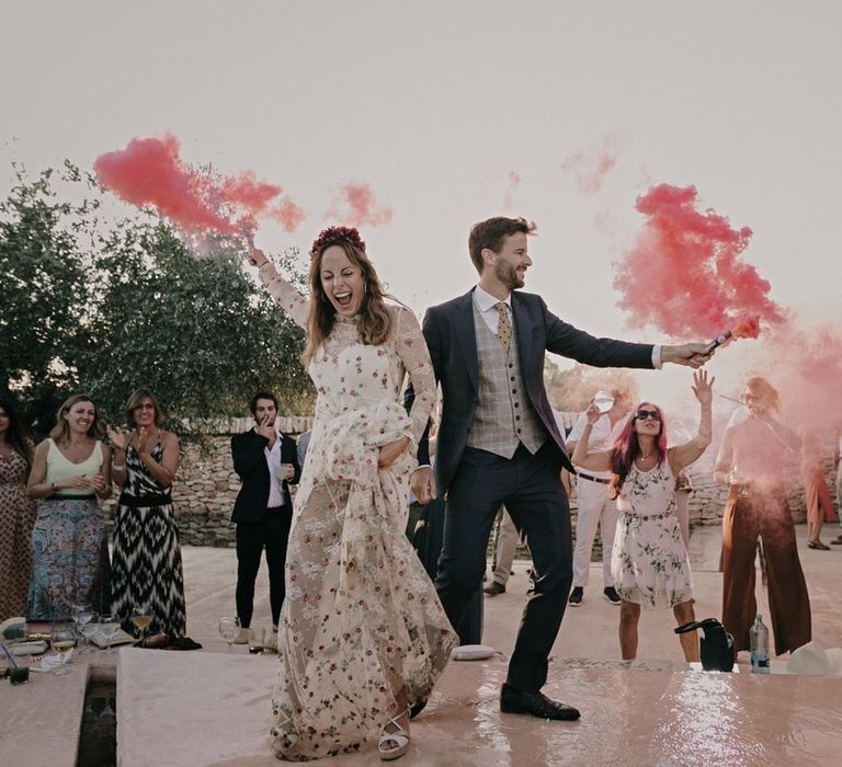 Bride and groom with pink smoke bombs