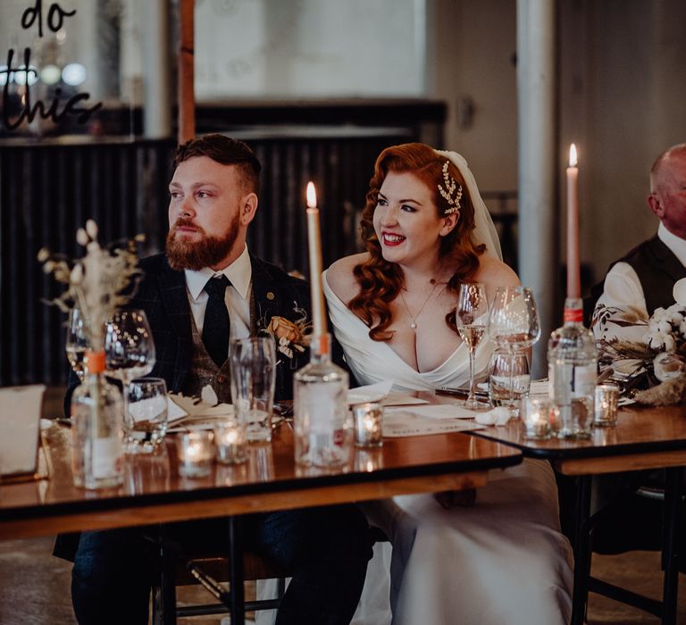 Bride and groom smiling during the wedding speeches at Holmes Mill 