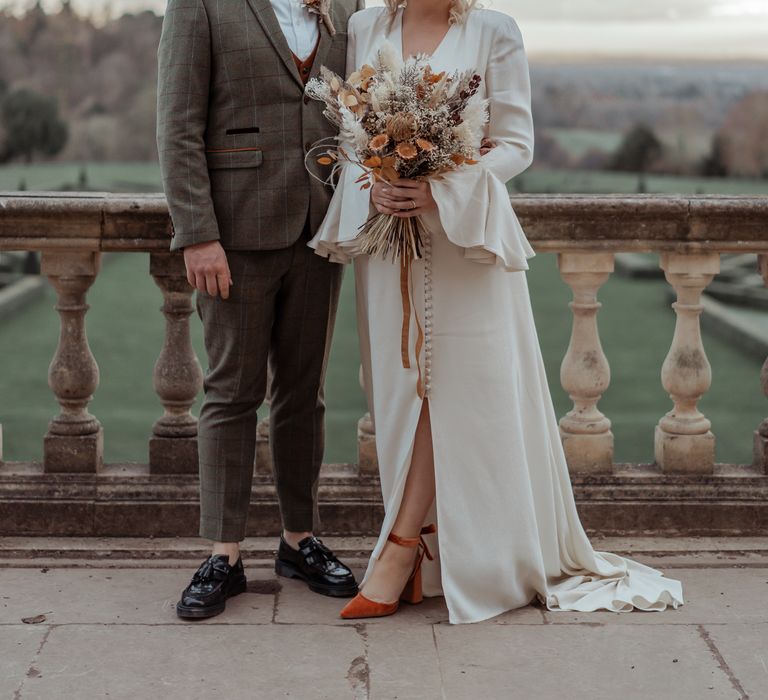 Bride & groom smile on the balcony of Cliveden House