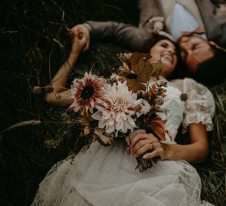 The bride holds a bouquet of gorgeous locally sourced flowers for her sustainable wedding