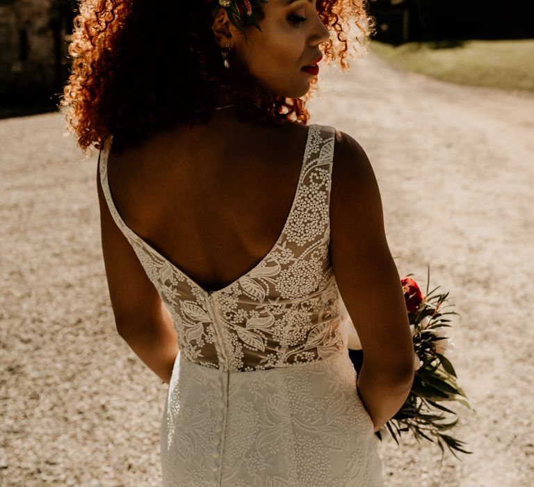 A Black bride wears her natural hair loosely as she poses for photo and looks over her shoulder