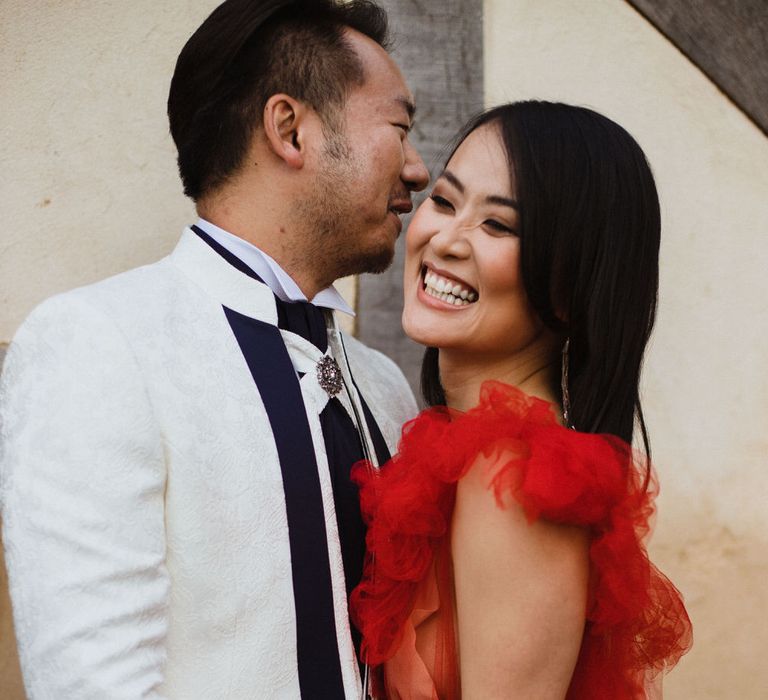 Red wedding dress and a white suit blazer for red and white themed wedding