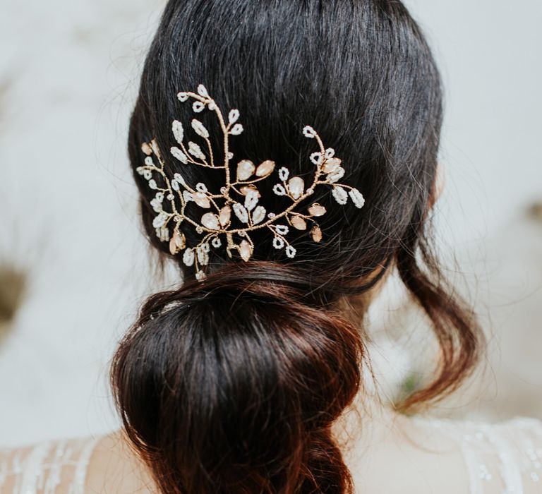 Traditional bridal hair pin with flower detailing and a low ponytail