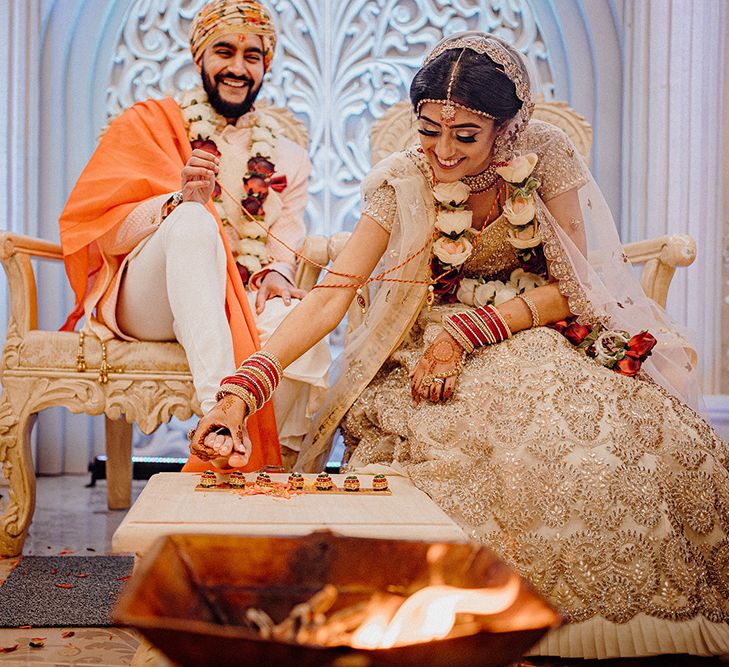 Hindu wedding ceremony with the bride and groom performing traditional rituals. 