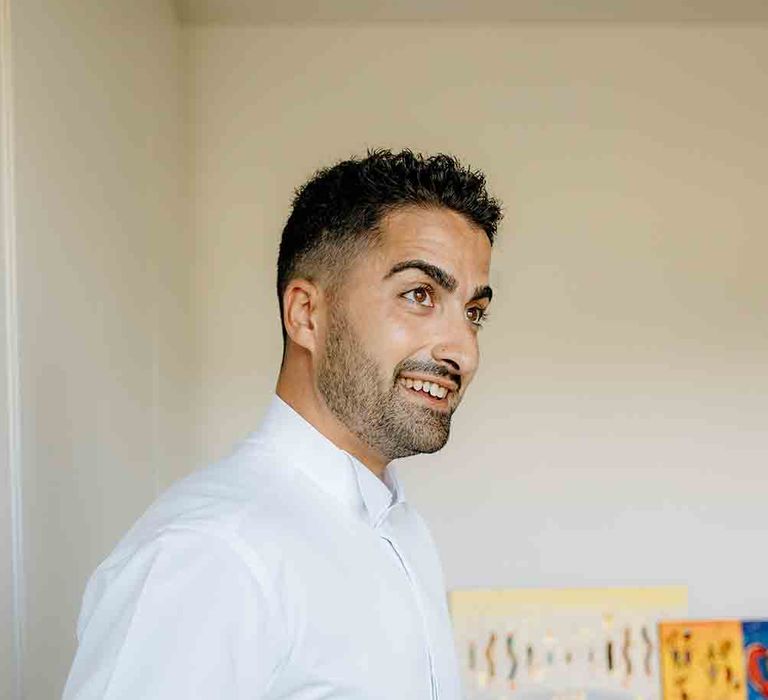 Groom in white shirt preparing for romantic Italian wedding