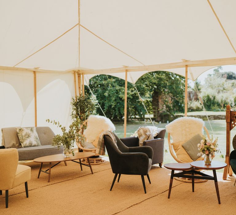 Chill area within marquee featuring mismatched sofas and tables