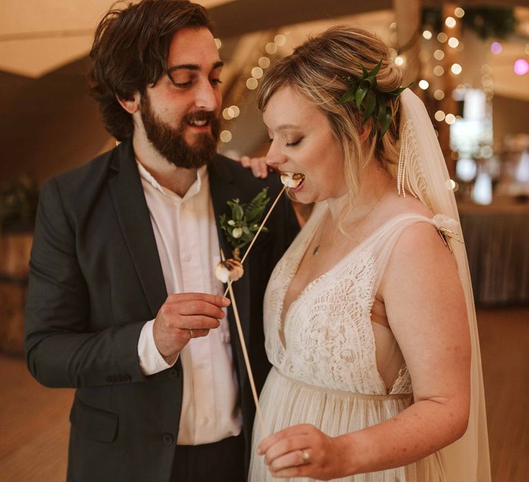 Bride & groom toast marshmallows in tipi