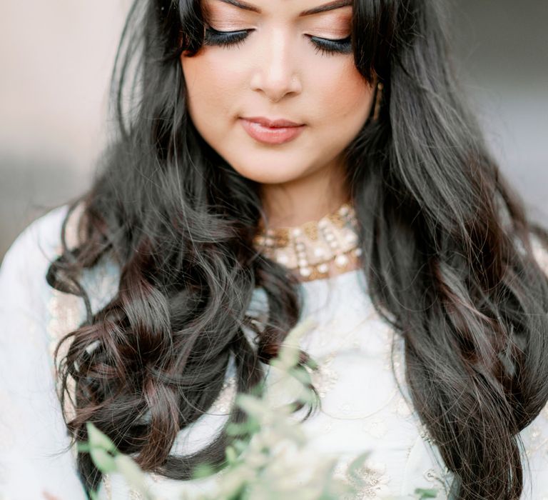 Beautiful Asian bride with long wavy hair, bindi and shimmering eye shadow 