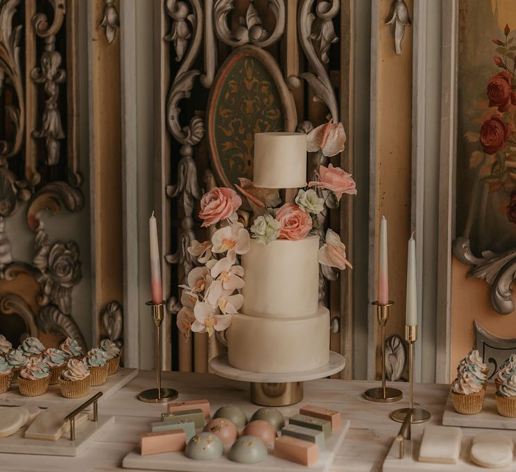 Wedding dessert table with three-tier cake, individual treats and cupcakes 