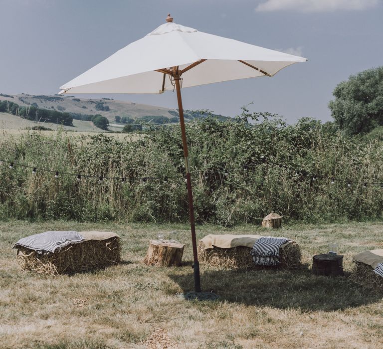 Hay bales and umbrella for festival style wedding