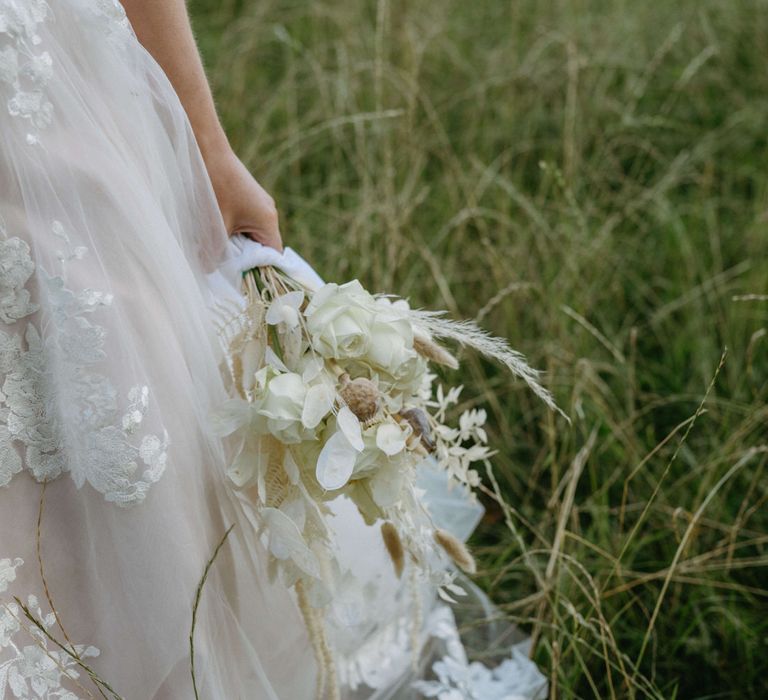 Embroidered tulle wedding dress with all white bouquet for boho style wedding