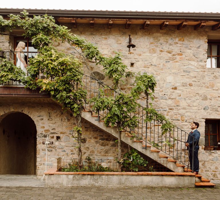 Bride and groom's first look, standing at the top and bottom of a staircase at their Italy elopement