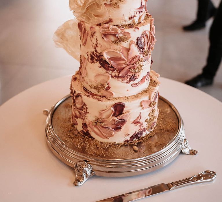 Pink and gold wedding cake with intricate design 