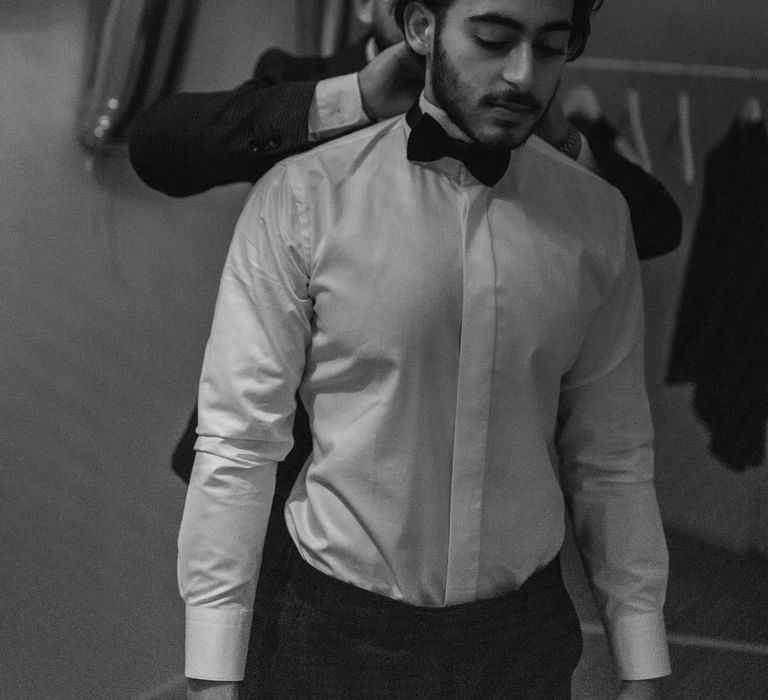 Groom gets ready on the morning of his wedding in black & white image