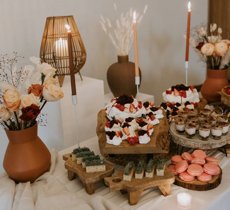 Wedding dessert table with neutral flower decor and rustic wooden boards