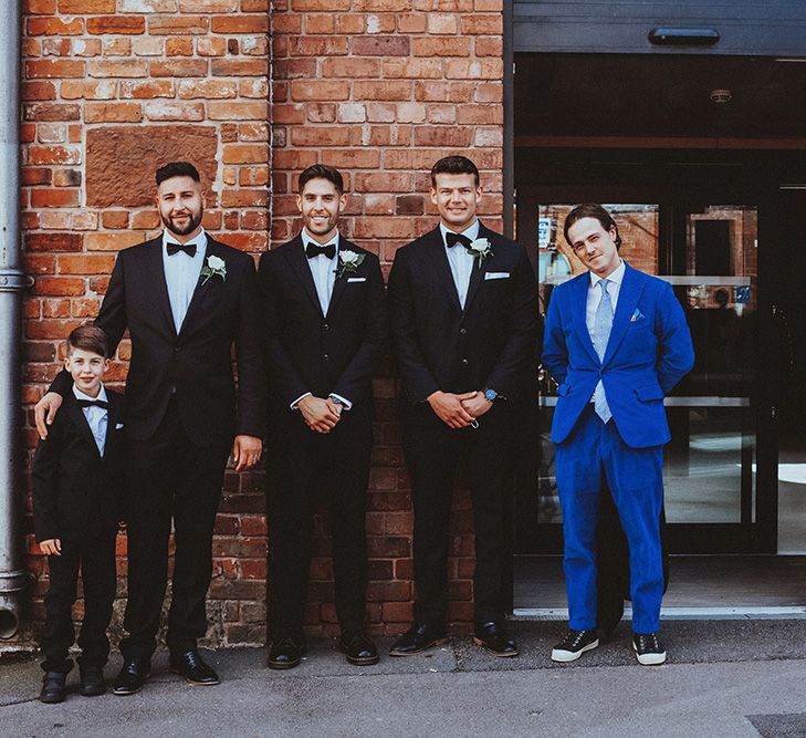 Groom and groomsmen in black tuxedos with bow ties 