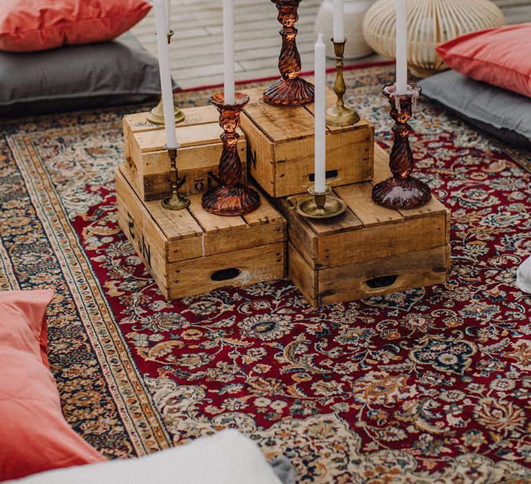 Outdoor seating area with rustic vibe complete with Moroccan style rugs and candlesticks 