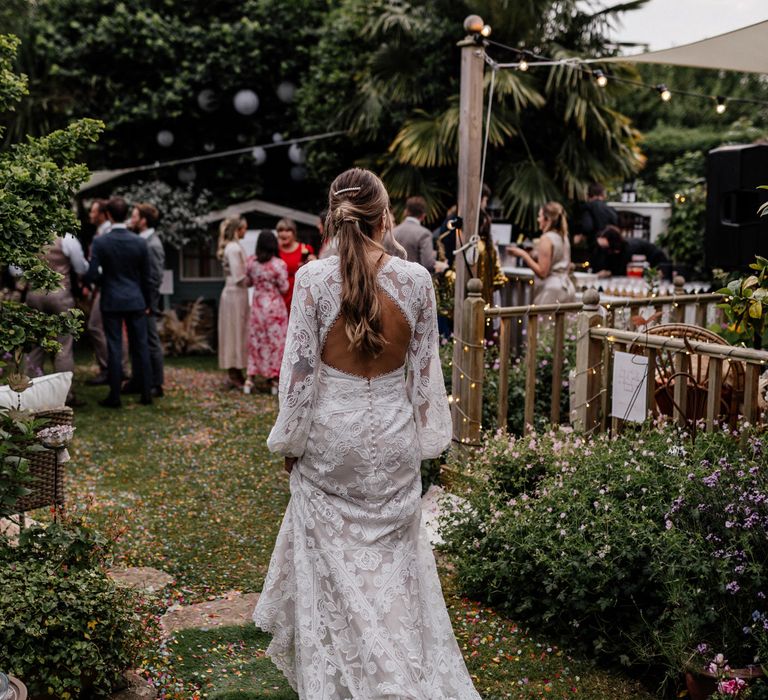 Open back lace wedding dress for bride with ponytail hairstyle 