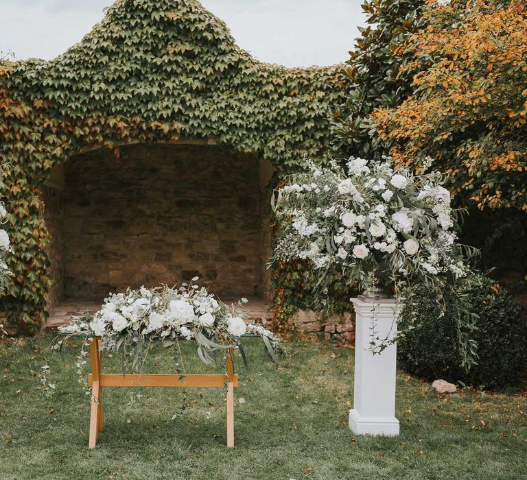 Outdoor aisle at Notley Abbey with green and white floral installations and garlands for outdoor wedding ceremony at Notley Abbey