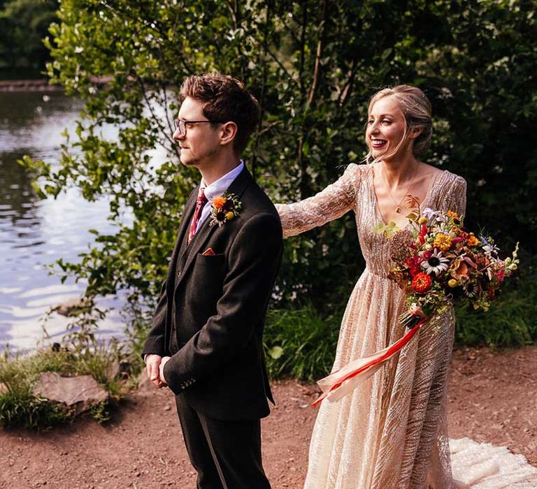 Bride taps groom on his shoulder for first look moment