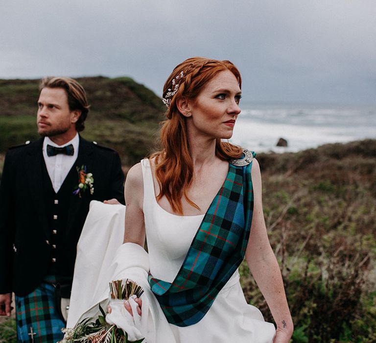 beautiful bride with auburn hair wearing a blue and green tartan sash over her princess wedding dress