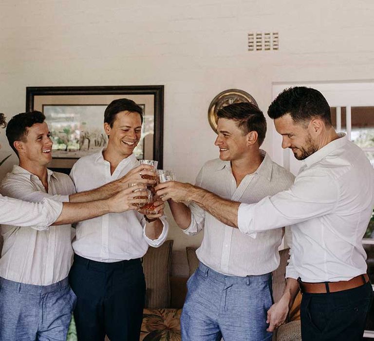 Groom's all cheers together before the wedding as they get ready together 